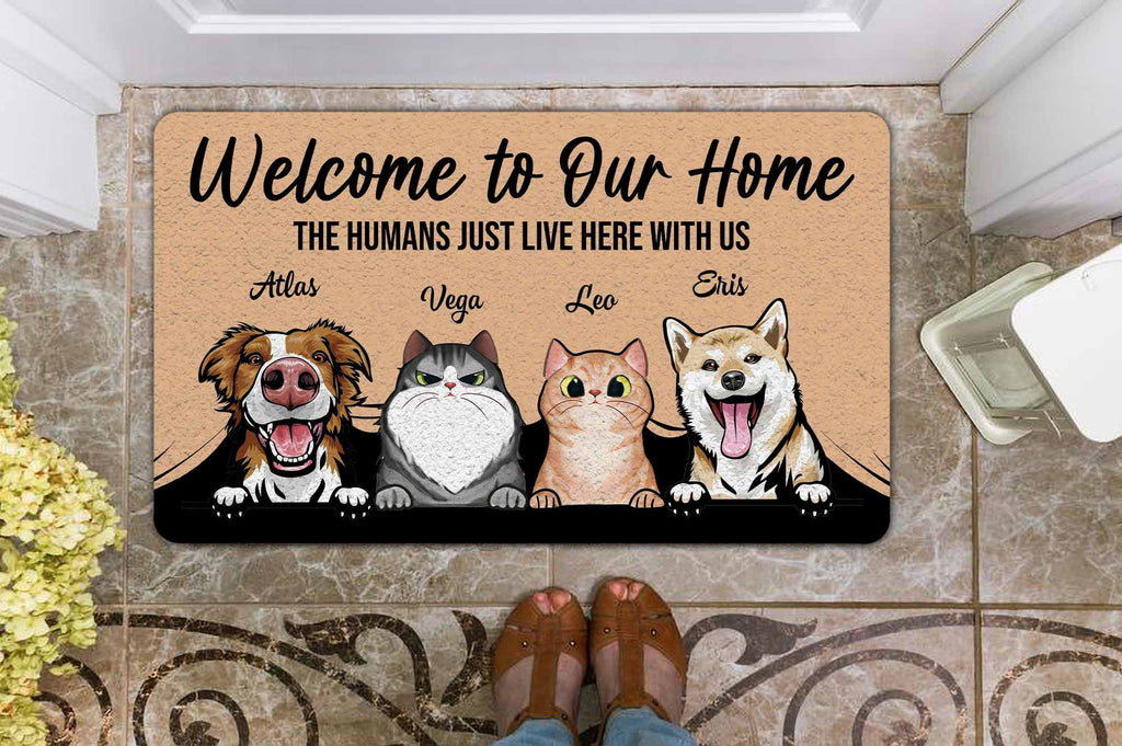 Doormat with cartoon dogs and cats and text 'Welcome to Our Home The Humans Just Live Here With Us'