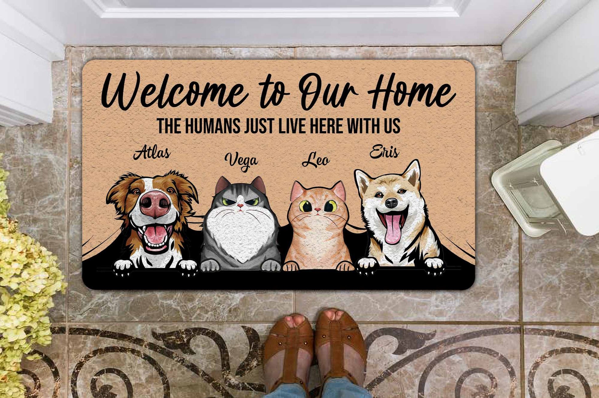 Doormat with cartoon dogs and cats and text 'Welcome to Our Home The Humans Just Live Here With Us'