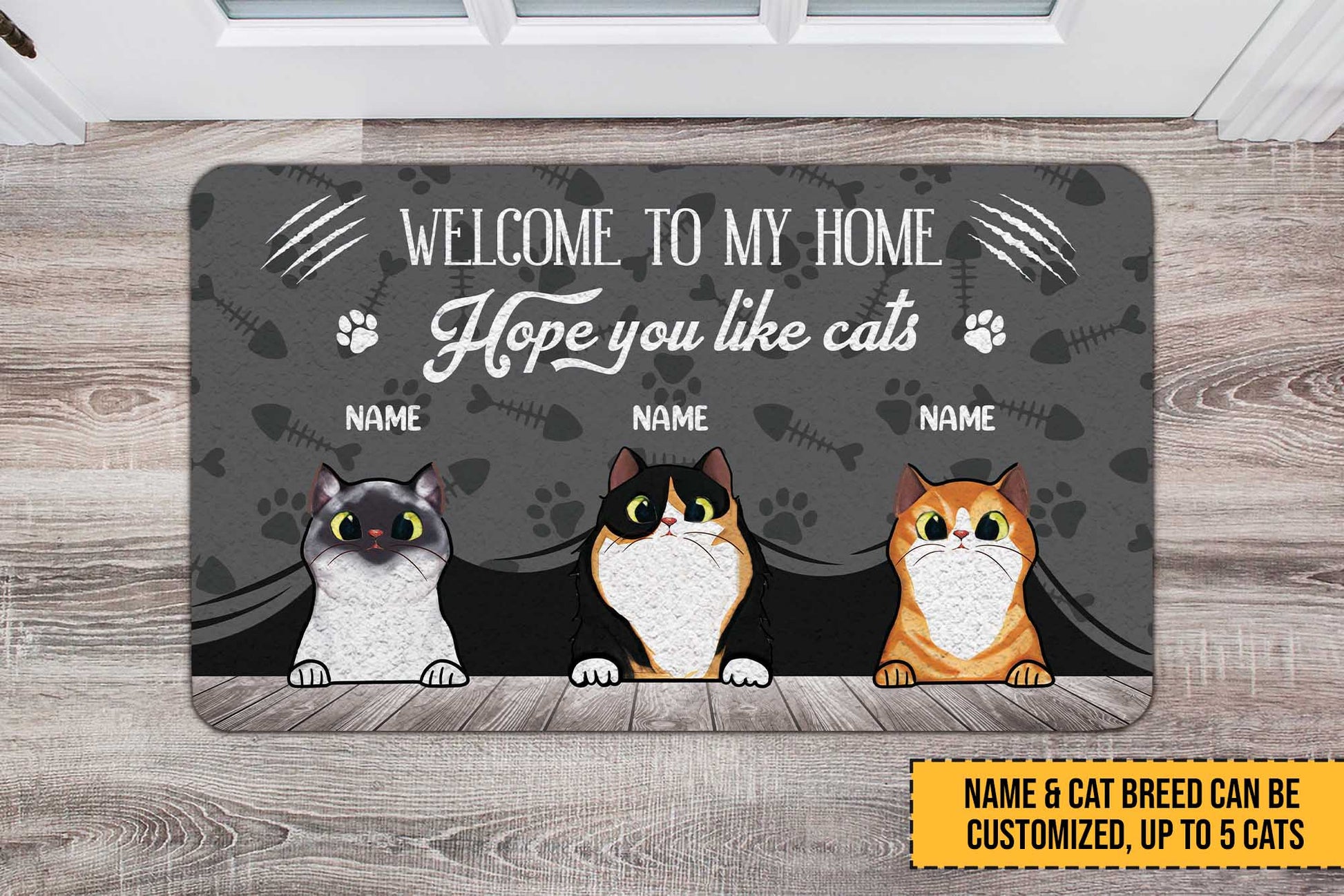 Personalized doormat with three cartoon cats and customizable text on a wooden floor.