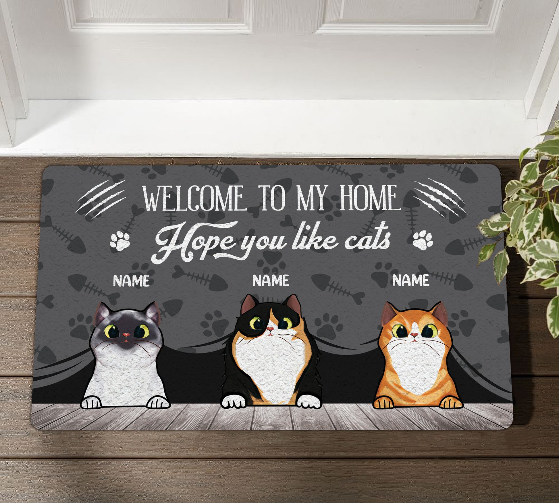 Doormat with three cartoon cats and text 'Welcome to my home, hope you like cats' on a wooden floor.