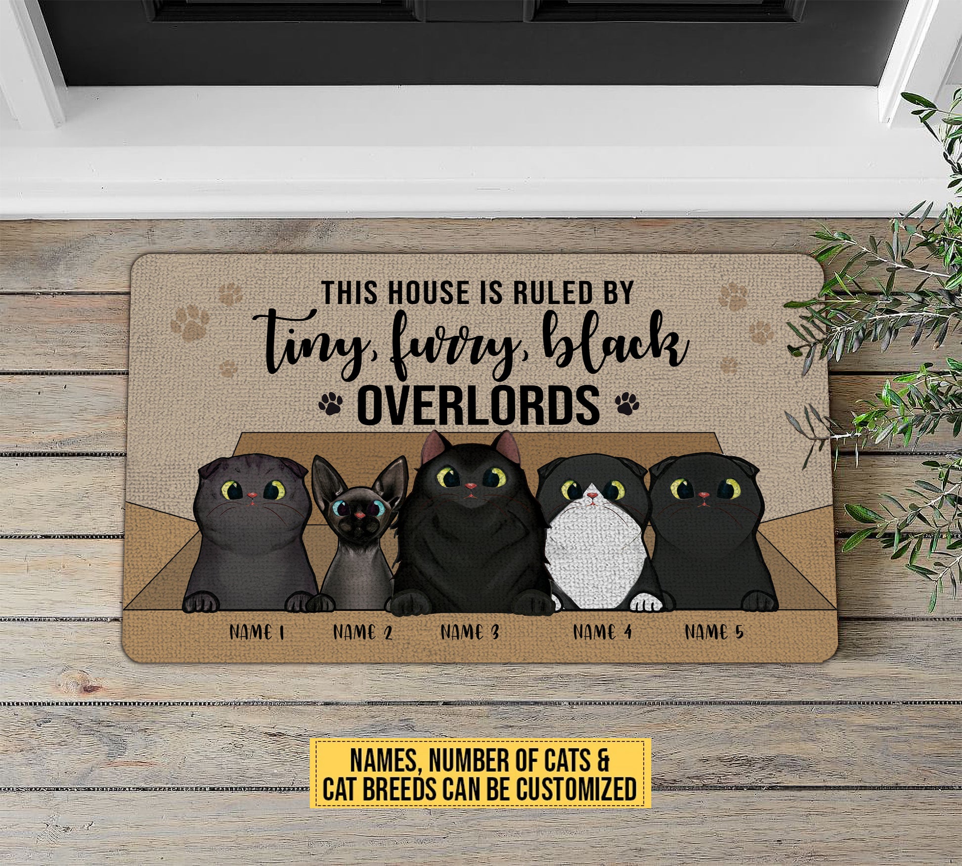 Doormat with cartoon cats and customizable text on a wooden floor.