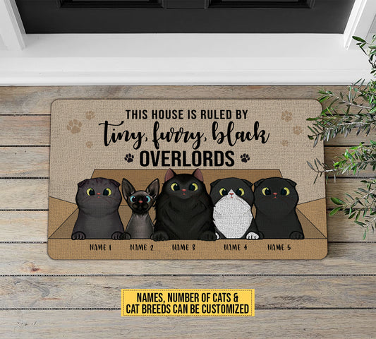 Doormat with cartoon cats and customizable text on a wooden floor.