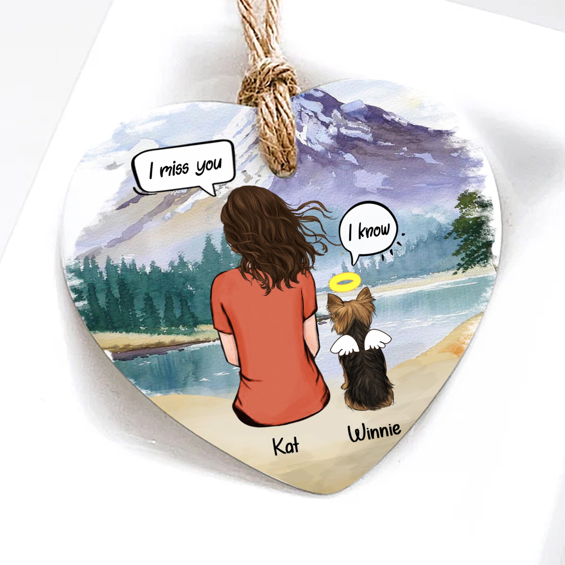 Heart-shaped ornament with illustration of a woman and her dog by a lake, with text bubbles and names.