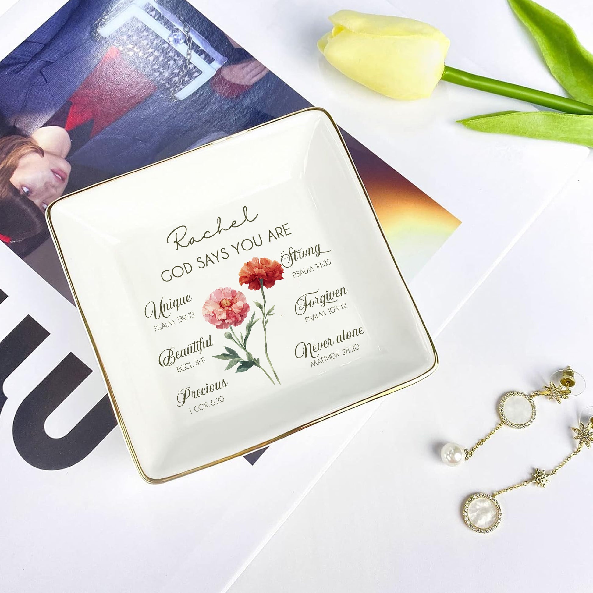 Decorative jewelry dish with motivational quote and flowers, placed on a magazine with tulips.