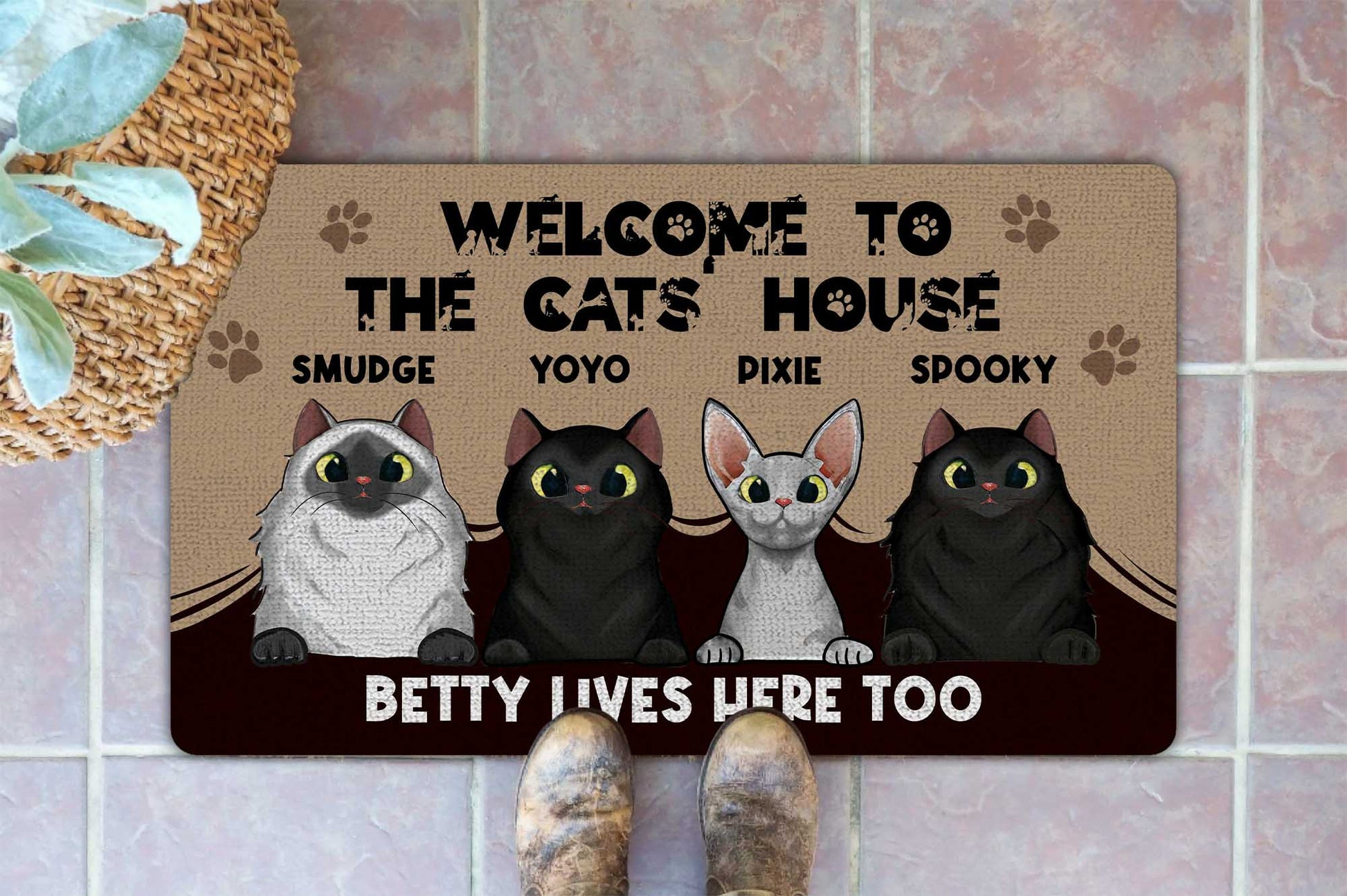 Doormat with cartoon cats and text 'Welcome to the cats house' on a tiled floor.