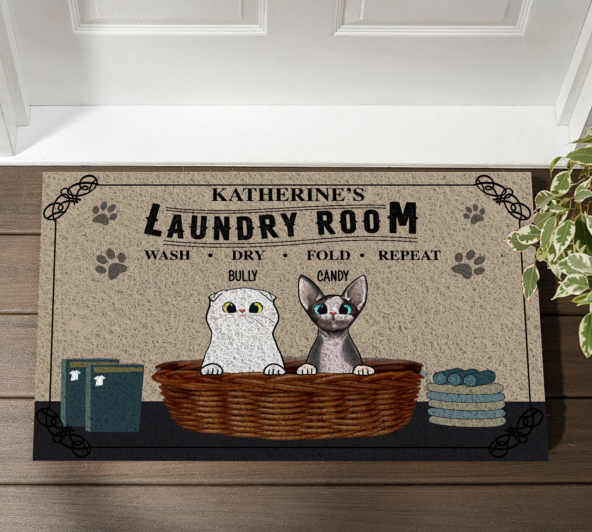 Doormat with cartoon cats and text 'Katherine's Laundry Room' on a wooden floor.