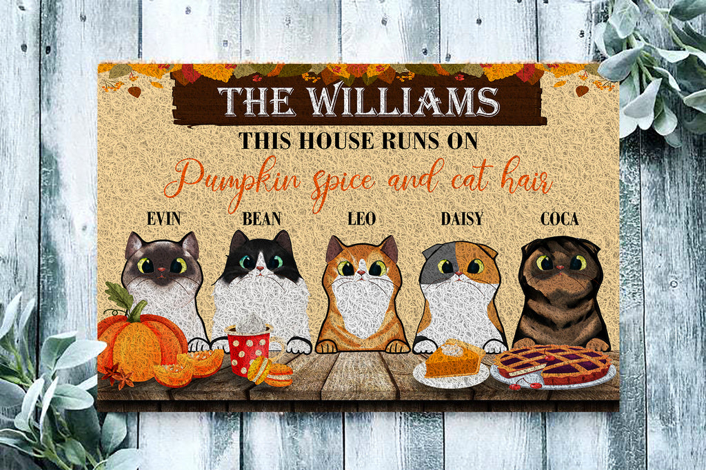 Personalized doormat with cat illustrations and text about pumpkin spice and cat hair on a wooden background.